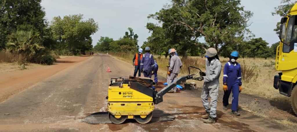 Road maintenance crew compacting cold-asphalt pothole repairs on the Madjo to Doba road, Chad