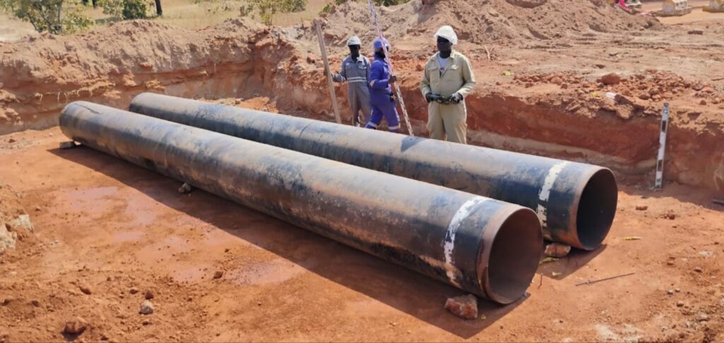 Steel culvert pipes staged for installation in an excavated trench between Madjo and Djen, Chad